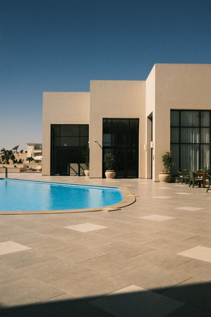 A contemporary villa featuring a luxurious swimming pool and sleek architectural design.